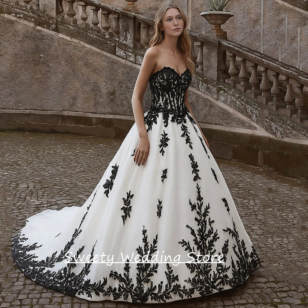 Robe de mariée gothique personnalisée bustier cœur sans manches applique noire traîne balayage fermeture éclair au dos robe de mariée traîne balayage